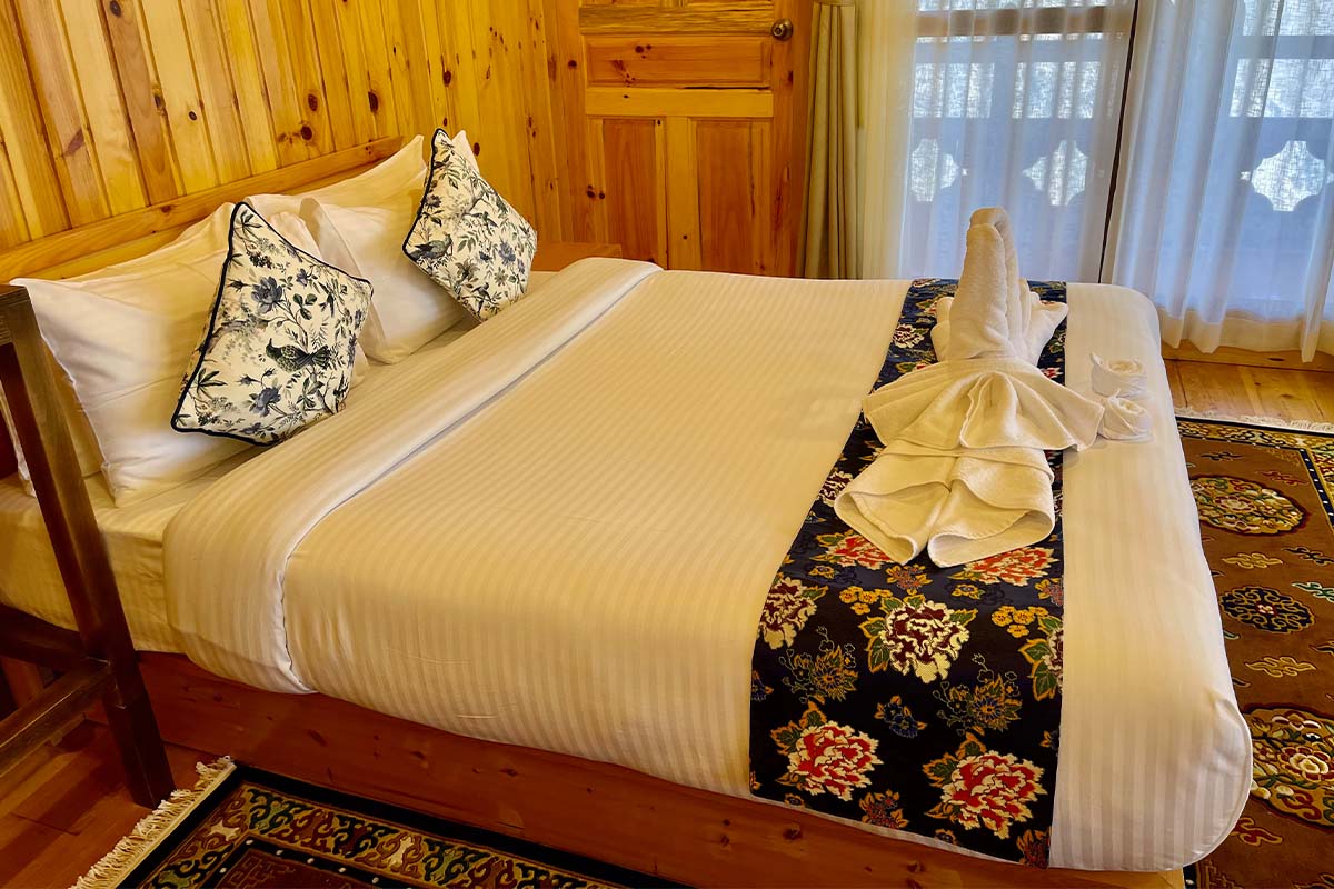 Suite with a queen bed and wood-panelled walls