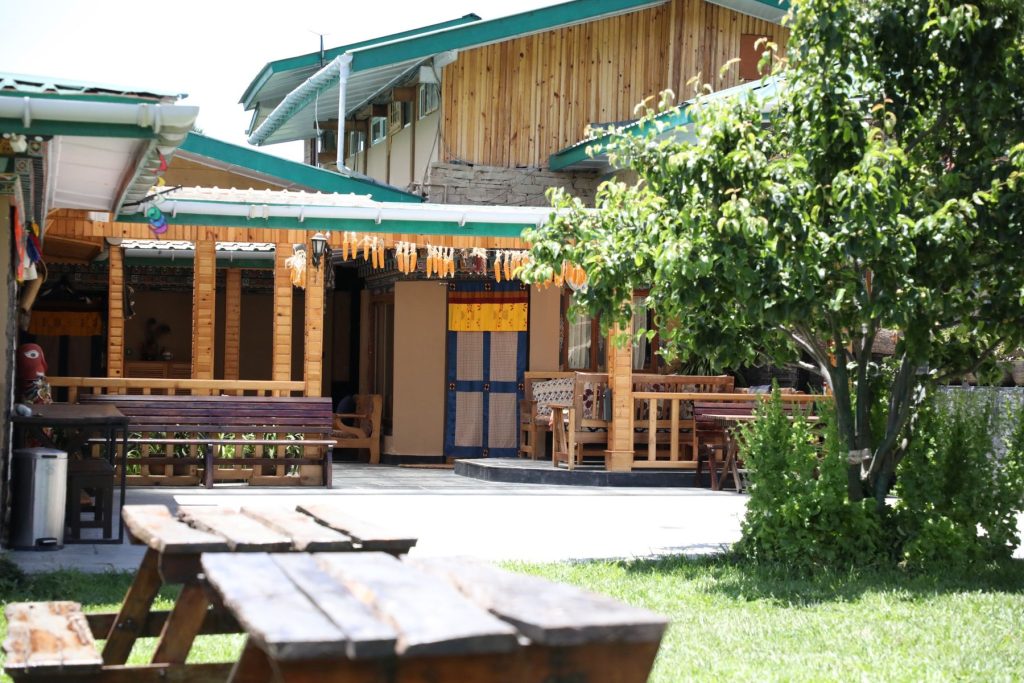 Wooden picnic tables in the courtyard of The Happiness Farm